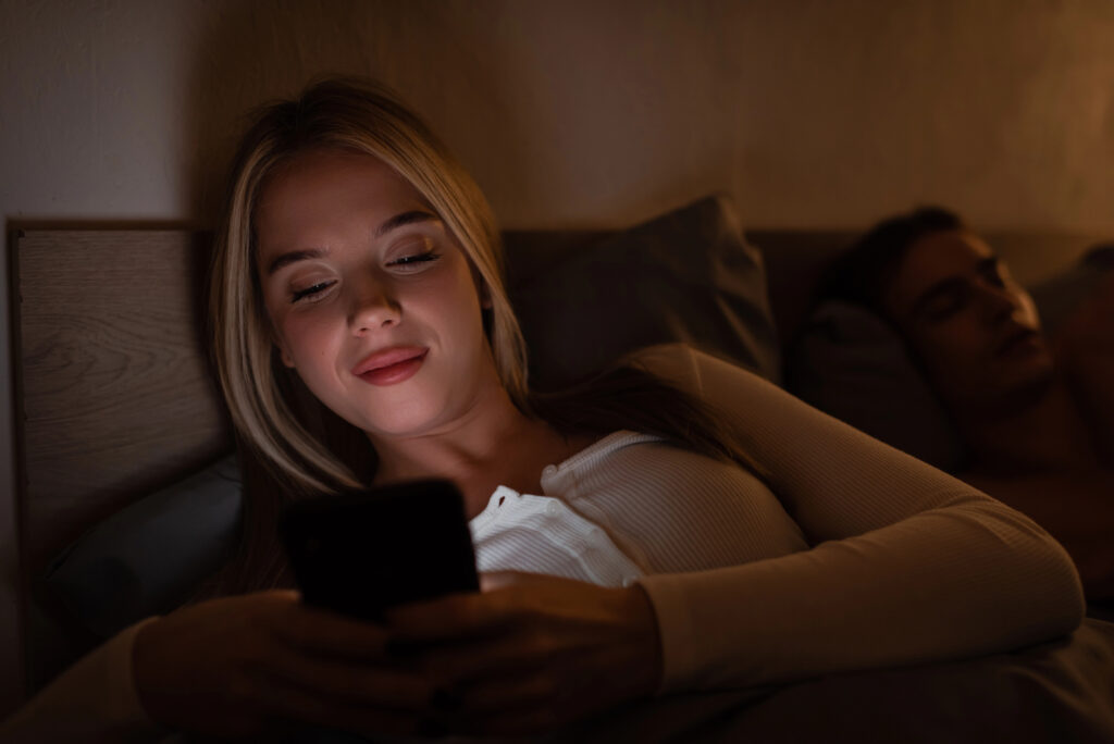 woman in bed using her phone with apps and app user acquisition