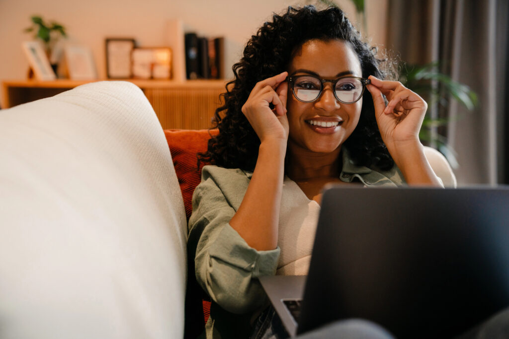 woman with glasses and computer looking at mobile app advertising